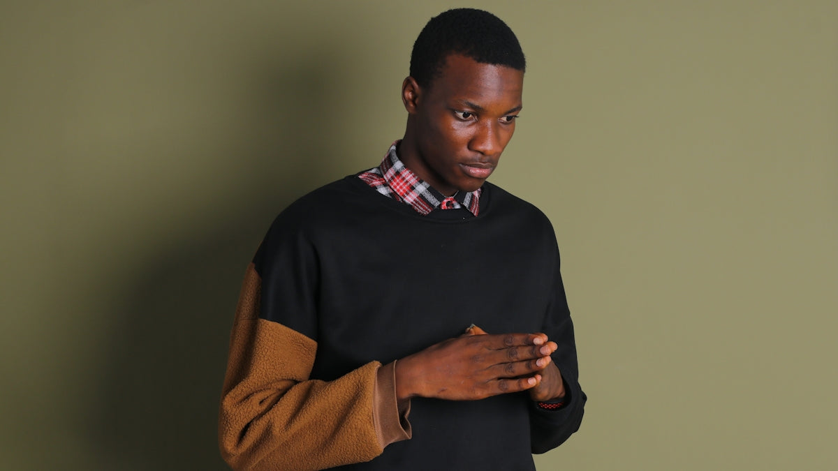 a man in a black sweater is holding his hands together